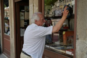 Man cleaning his store front.