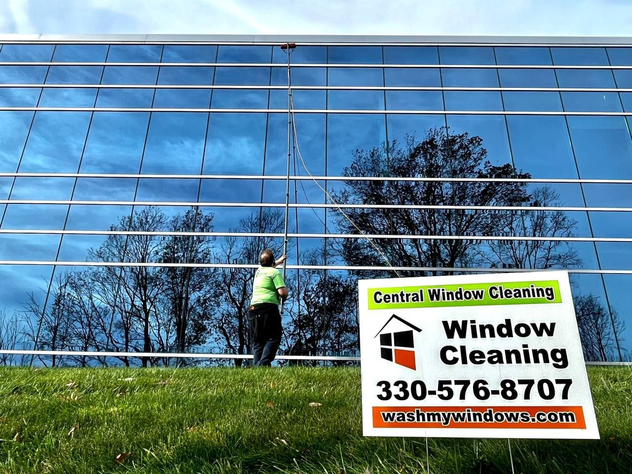Two Central Window Cleaning technicians washing windows on a brick residential home, Akron OH area