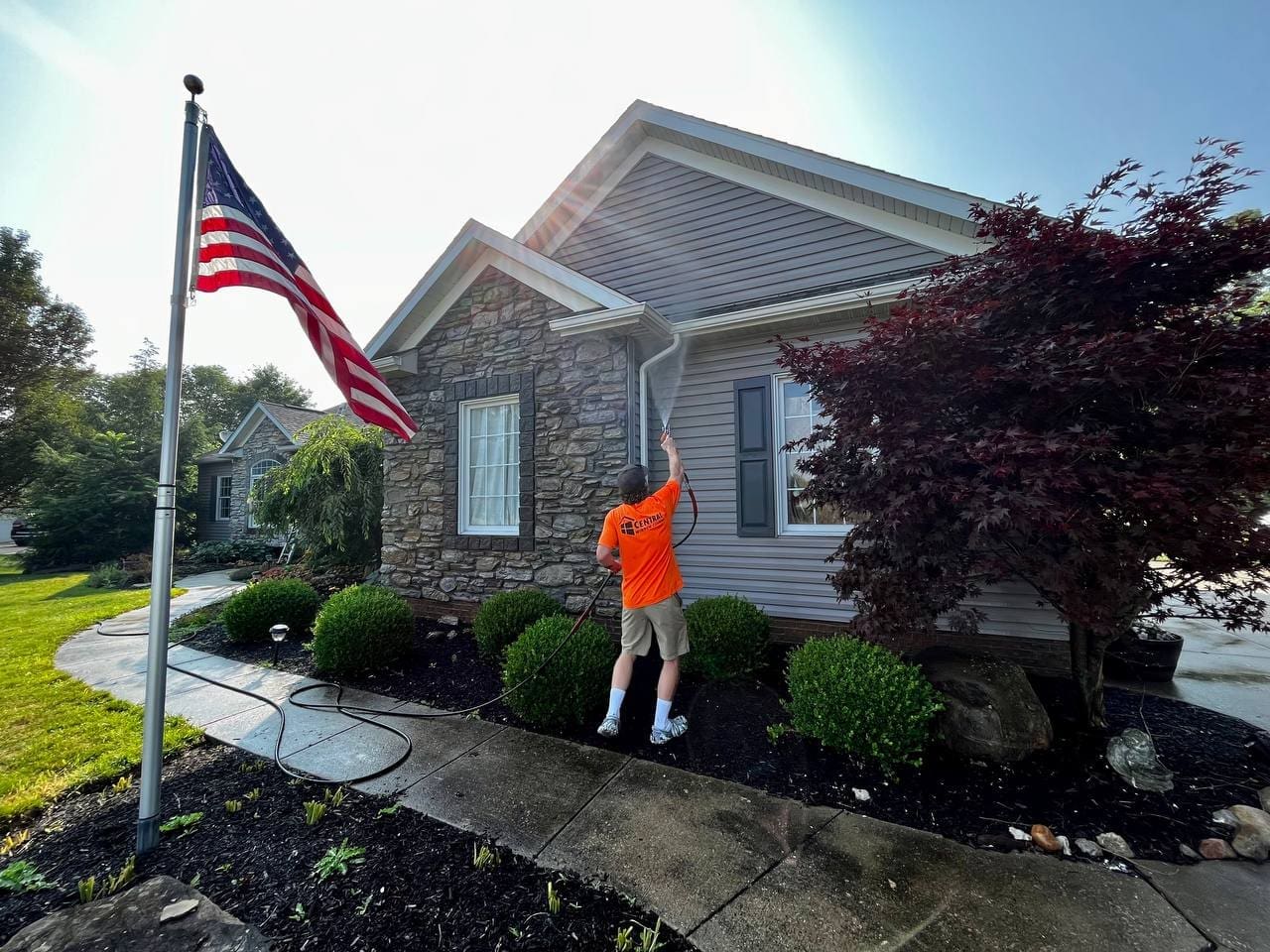 Central Window Cleaning technician cleaning exterior windows and trim on a residential home, Akron OH area